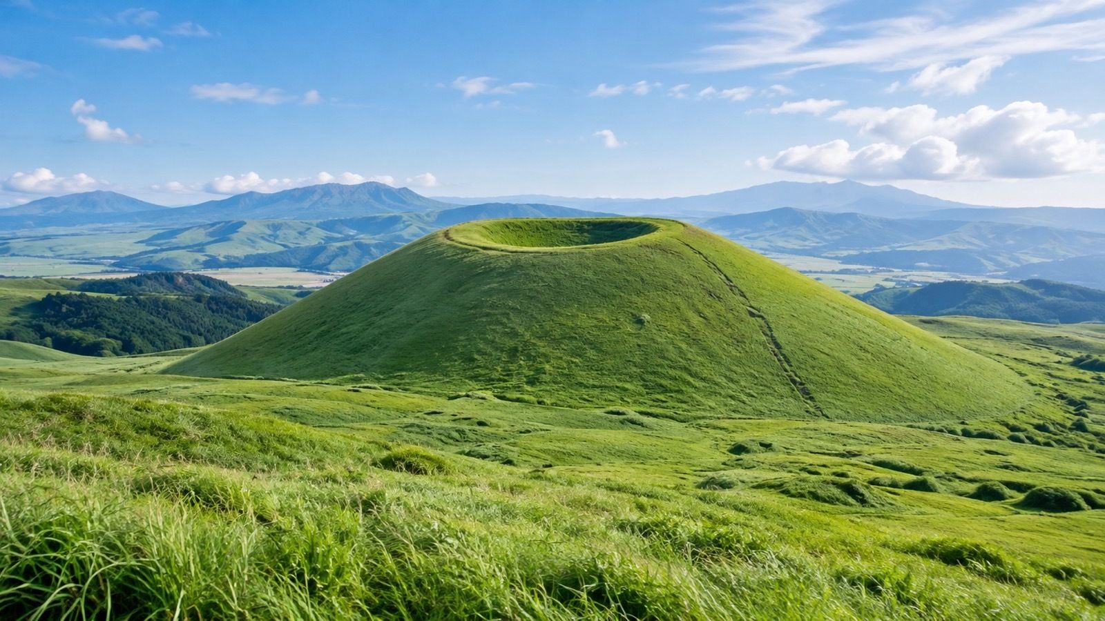 草原の中に立つ円すい形の小さな山