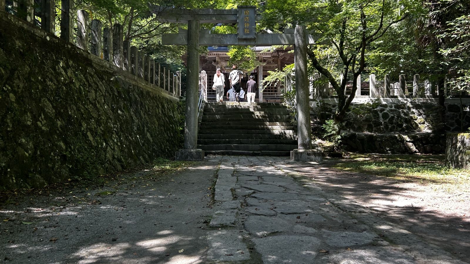 国造神社の鳥居と石段を上る参拝者の後ろ姿