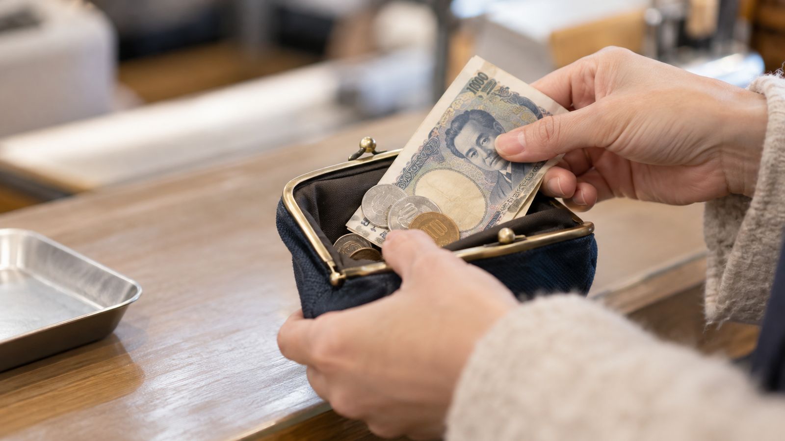 小銭入れからお札と硬貨を出す手元