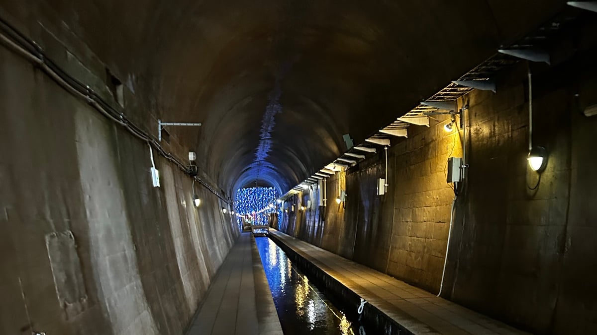 高森湧水トンネル公園のトンネルの中。石畳の通路と水路が奥へ続く