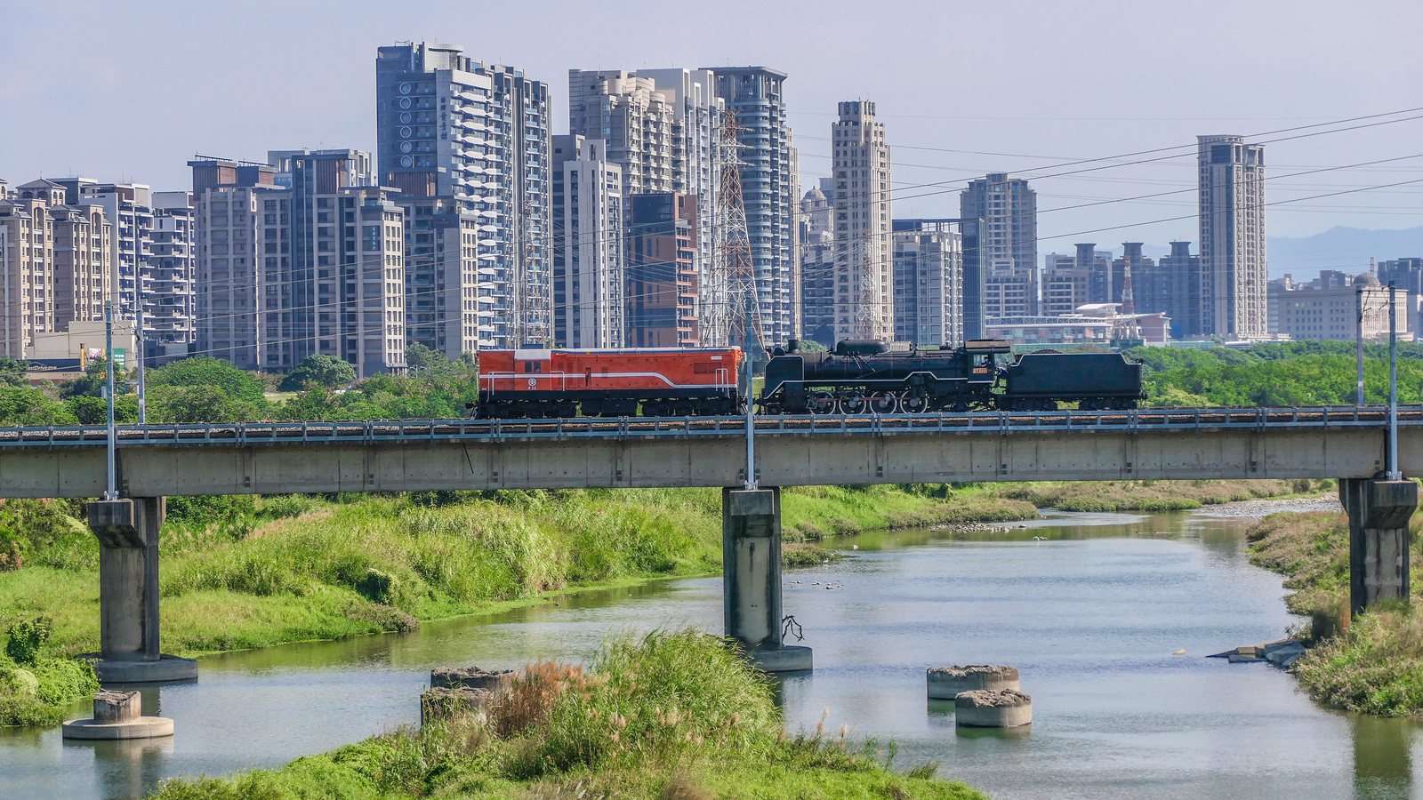 竹北の高層マンションと鉄橋を走る列車