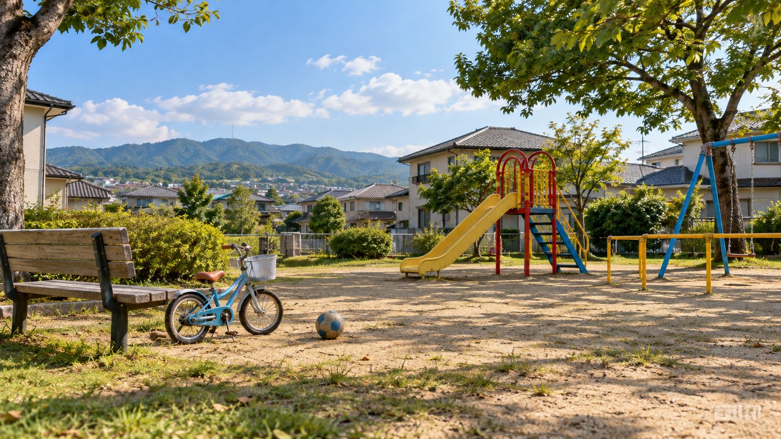 公園の滑り台のそばに置かれた子ども用自転車とボール